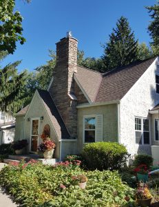 Front exterior of a home with a custom built stone chase buildout. Built and installed by Carter Custom Construction, your trusted builder for fireplaces and chase buildouts.