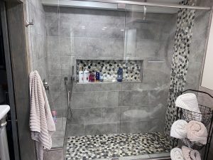 gray-modern-bathroom-remodel-home_twin-cities-mn Remodeled bathroom shower with gray tile and a speckled accent rock looking tile, built by Kitchen remodel with open shelving and white cabinets, by Carter Custom Construction