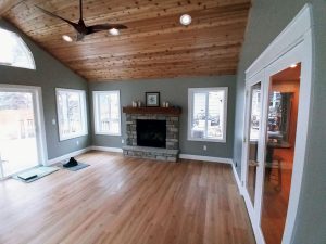 home-addition-sunroom-remodel-fireplace_st-paul_mn Porch addition with stone fireplace and wood live edge mantel, built by Kitchen remodel with open shelving and white cabinets, by Carter Custom Construction