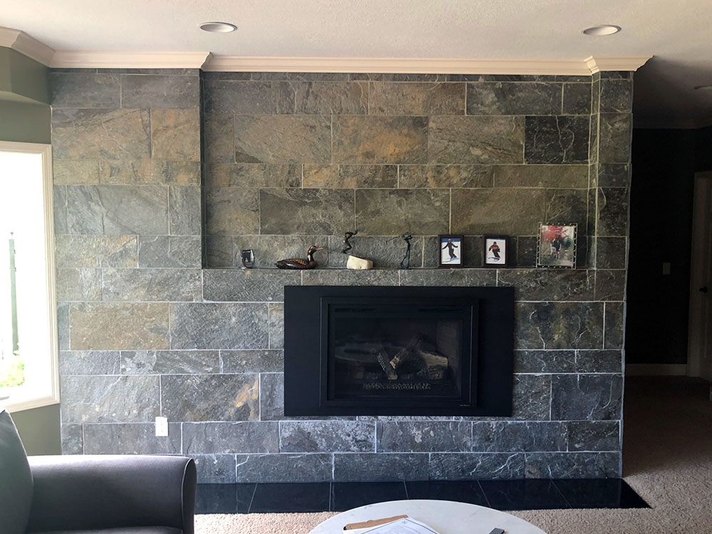 Modern living room with a sleek stone fireplace and minimalist decor, completed by Carter Custom Construction.