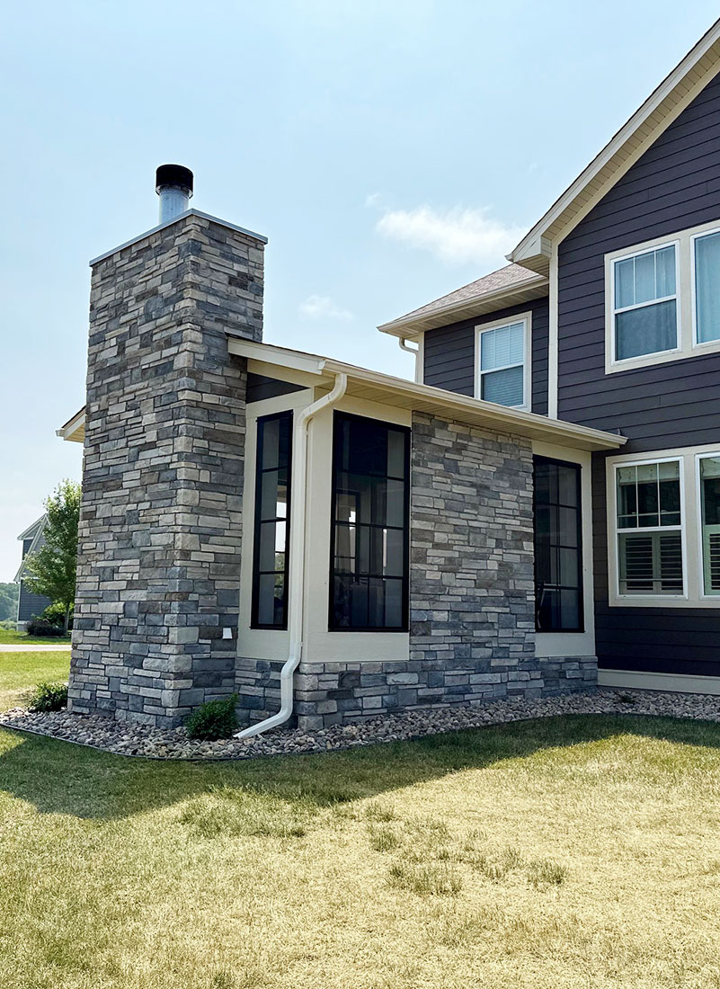 custom four seasons porch addition with stone accent and stone fireplace